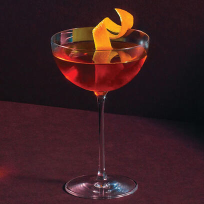 A sophisticated mix of gin, sweet vermouth, and amaro, finished with a loquat peel garnish.